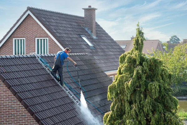 Cleaner with pressure washer at roof house cleaning roof tiles — Stock Photo, Image