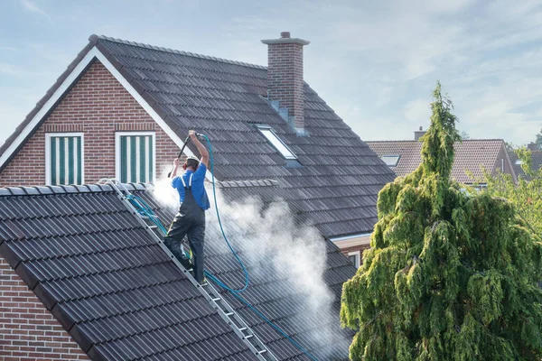 Cleaner with pressure washer at roof house cleaning roof tiles — Stock Photo, Image