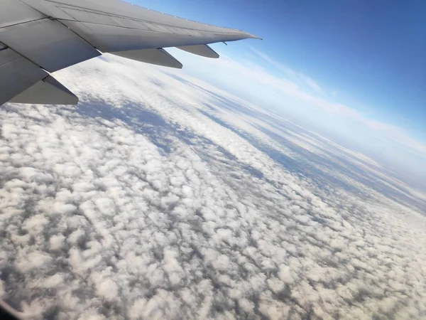 Blick aus dem Flugzeugfenster auf Flügel und Wolken — Stockfoto