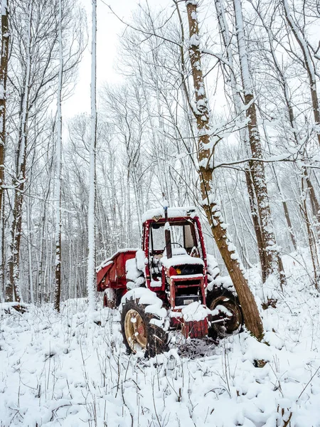 Abandoned tractor in the snow, pollution