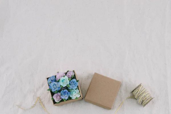 ブラウン ギフト ボックスとロープはモスリン生地コピー スペースと青色のトーン紙の花 花ボックスの選択と集中で飾る — ストック写真