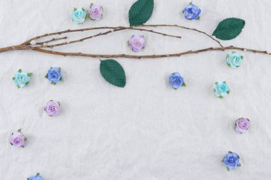 Kahverengi şube mavi tonu gül kağıt çiçeklerle süslemek ve muslin kumaş kopya alanı ile yeşil yaprak