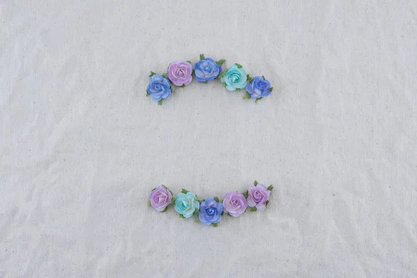 Wreath made from blue tone rose paper flowers on muslin fabric with copy space