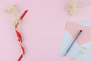 Beyaz boş pembe kart örtmek ve çiçekler kopya alanı ile pastel pembe arka plan üzerinde siyah beyaz kalemle kurutulmuş