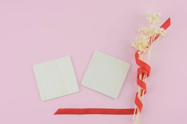 İki boş kahverengi ahşap süslemeleri ile kopya alanı pastel pembe zemin üzerine beyaz Kuru çiçekler Buket