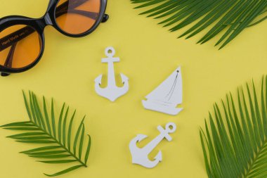 Eğreltiotu yaprakları ve küçük Yelkenli ve sarı zemin üzerine çapa ile güneş gözlüğü süslemeleri