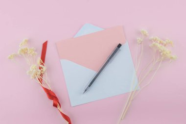 Boş beyaz kartı, kahverengi hediye kutusu ve ip kopya alanı pastel pembe zemin üzerine beyaz Kuru çiçekler Buket ile süsleyin