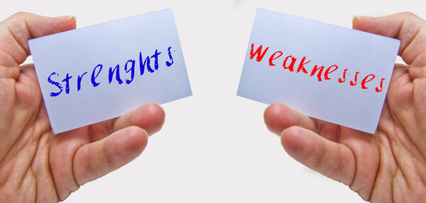 man hands holding cards with the words strenghts and weaknesses for swot analysis