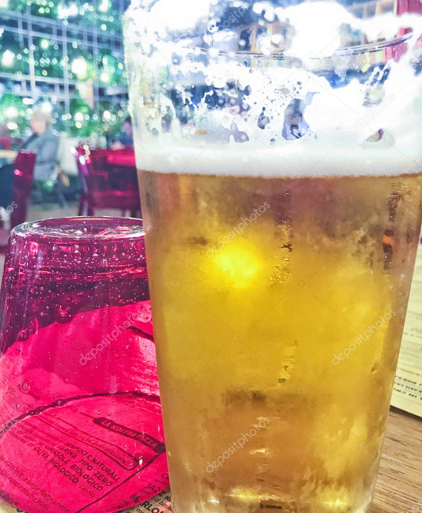 frosty golden glass of beer in a pizzeria restaurant 