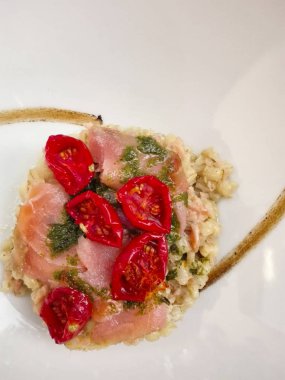 Hecelenmiş, somon ve yeşil sos ve kavrulmuş soğan krema ile pachino domates