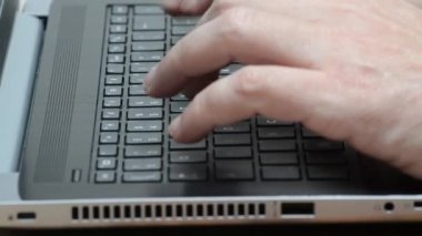 Beyaz, beyaz, beyaz bir adam dizüstü bilgisayar klavyesinde yazı yazıyor. Akıllı çalışma, iletişim, programlama, yazma konsepti