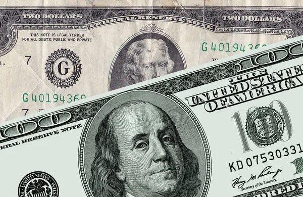 Доллары США номиналом в сто долларов и два фунта — стоковое фото