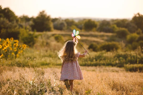 小麦の夏の畑で遊ぶかわいい女の子 — ストック写真