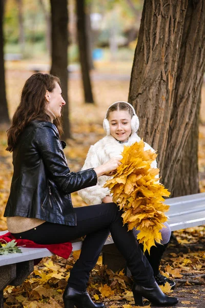 happy mother with her daughter in the autumn park