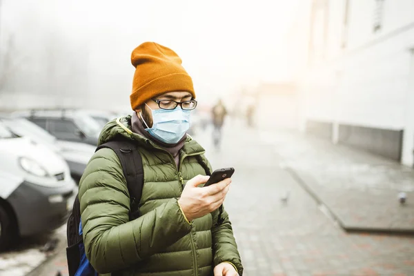 Un hombre con una máscara en la calle. Protección contra virus y agarre — Foto de Stock