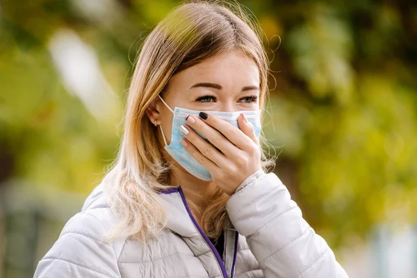 Mujer enferma y con mascarilla facial. Mujer con máscara protectora sintiéndose mal en la calle en la ciudad con contaminación del aire. Humo, contaminación del medio ambiente . — Foto de Stock