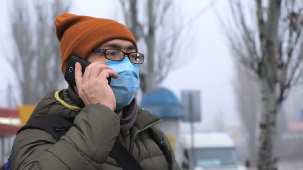 Un hombre con una máscara en la calle. Protección contra virus y contaminación — Vídeos de Stock