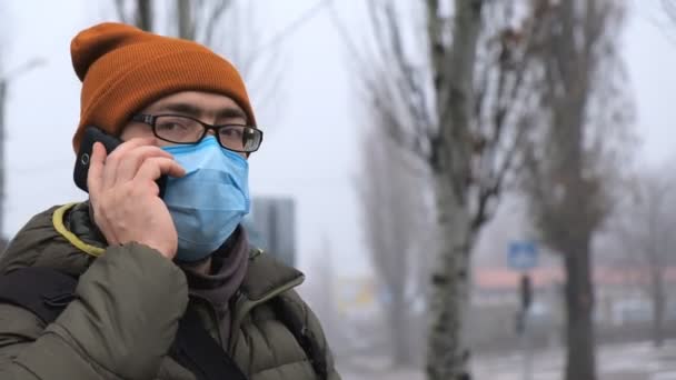 Un hombre con una máscara en la calle. Protección contra virus y contaminación — Vídeo de stock