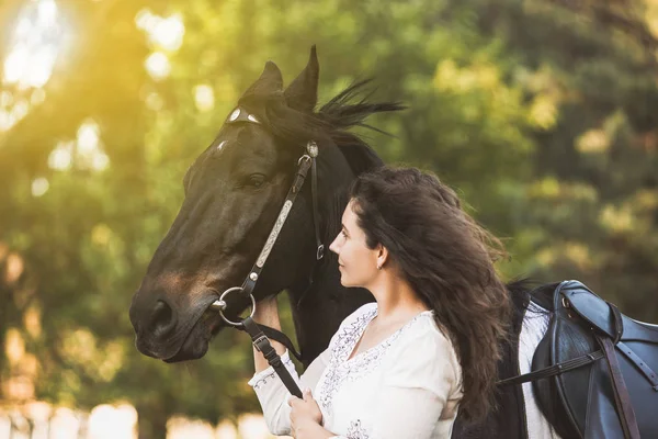 Smiling girl hugs her horse pet — Stock Photo, Image