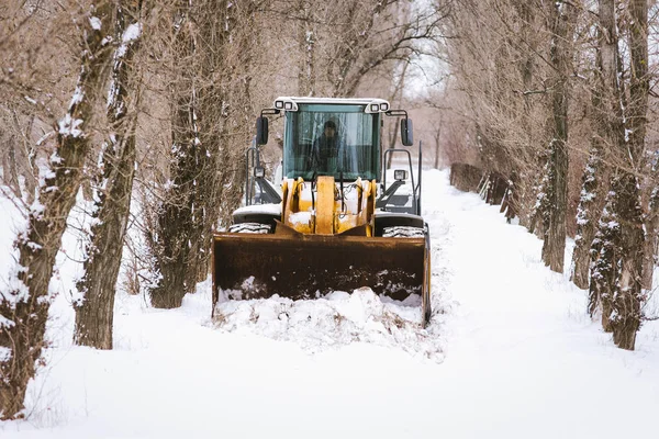 Cleaning the streets of the city from the snow with the help of special machinery bulldozer