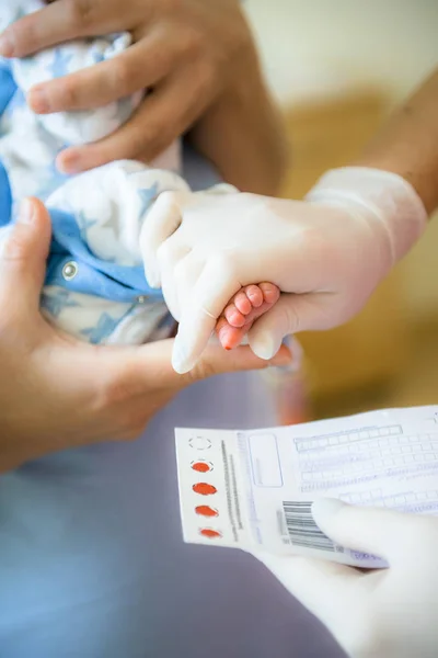 Médico faz um exame de sangue em recém-nascidos — Fotografia de Stock