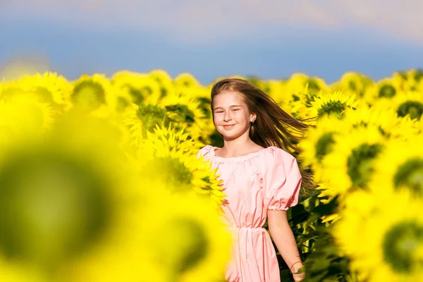 귀여운 소녀 에 해바라기 필드 포즈 용 카메라, 조화 와 자연, 젊은 모델 — 스톡 사진