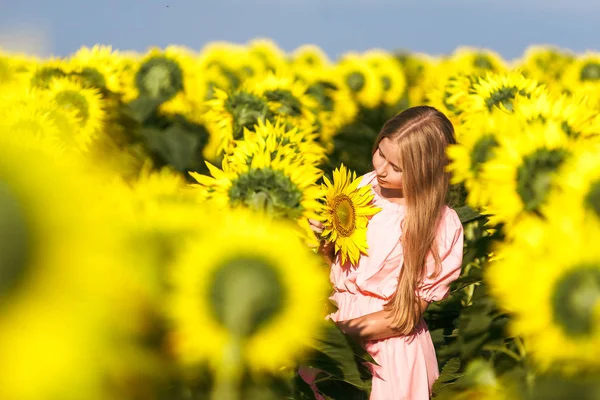 Hezká dívka, která stála mezi slunečnic a pózala pro kameru s očima zavřených — Stock fotografie