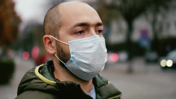 Een man met een masker op straat. Bescherming tegen virus en grip — Stockvideo