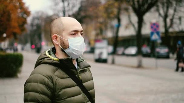 Мужчина в маске на улице. Защита от вирусов и сцепления — стоковое видео