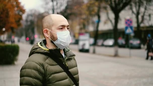 Un hombre con una máscara en la calle. Protección contra virus y agarre — Vídeos de Stock