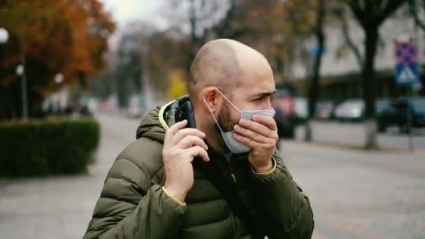 Ένας άντρας σε μια μάσκα στο δρόμο. Προστασία από ιούς και μόλυνση — Αρχείο Βίντεο