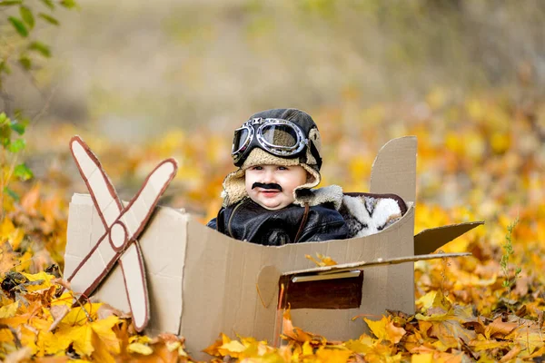 Πολύ χαριτωμένο αγόρι που κάθεται σε αεροπλάνο από χαρτόνι, μελλοντικός πιλότος, επάγγελμα όνειρο ζωής — Φωτογραφία Αρχείου