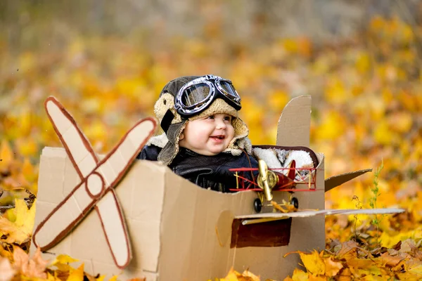 Ragazzo molto carino seduto in aereo di cartone, futuro pilota, professione sogno a vita — Foto Stock