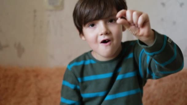 一个英俊的小男孩表示他的乳牙掉了.儿童更换牙齿的概念 — 图库视频影像