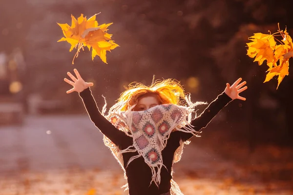 Hermosa chica cabeza roja sosteniendo hojas de otoño y posando para la cámara, foto colorida — Foto de Stock