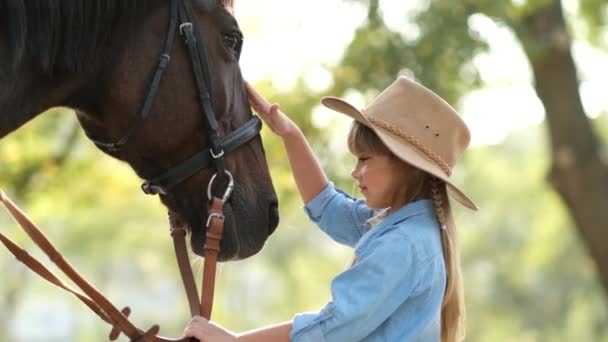 Маленька дівчинка з розладом аутизму погладжує красивого коня на відкритому повітрі. Тваринна терапія — стокове відео
