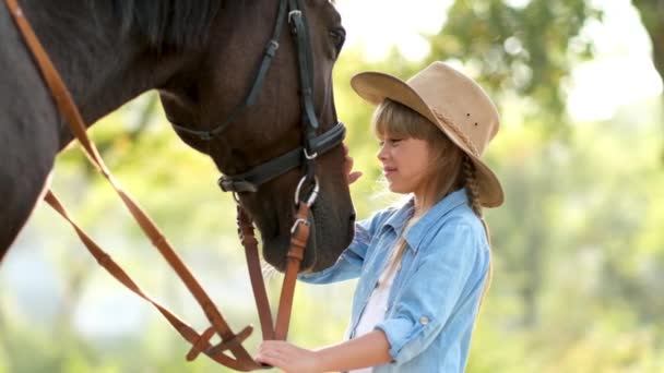 Dziewczynka z zaburzeniami spektrum autyzmu głaskająca pięknego konia na świeżym powietrzu. Leczenie zwierząt domowych — Wideo stockowe