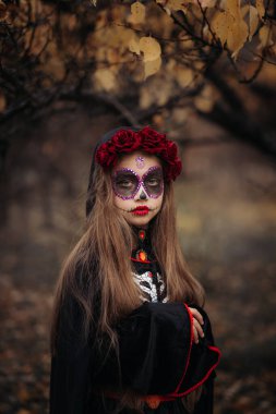 Cadılar Bayramı 'nda karanlık bir ormanda kafatası makyajlı bir cadı..