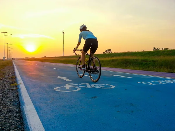 Bike path with a symbol of bike. Cyclist moving on an empty bicycle lane in sunset lights