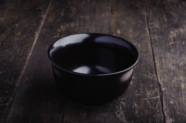 Grunge ahşap arka plan üzerinde boş siyah porselen kase