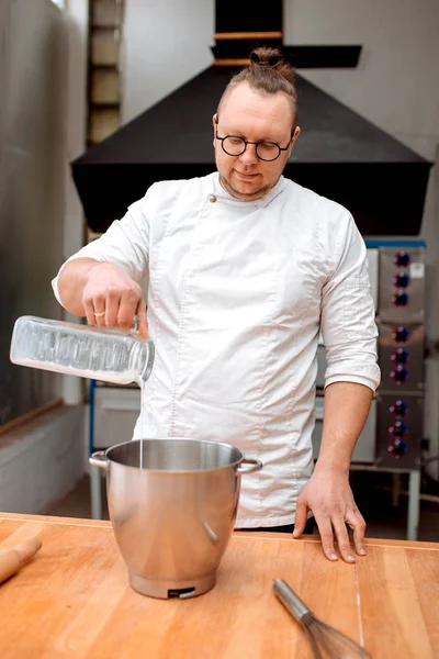 A man chef prepares cupcakes in the kitchen