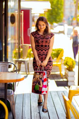 İçinde bir alışveriş caddesi üzerinde sonra paketleri ile neşeli kadın