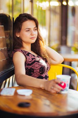 Sokakta bir kafede bir masada kahve ile güzel kadın