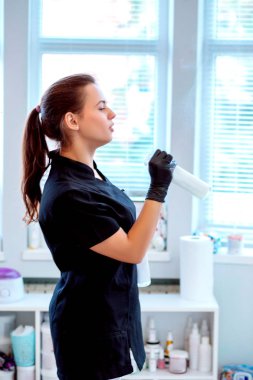 Kadın doktor güzellik uzmanı eldiven ve antibakteriyel sprey ile