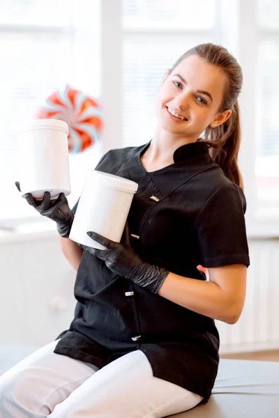 Portret Van Een Schoonheidsspecialiste Een Zwarte Jas Een Crème Pot — Stockfoto