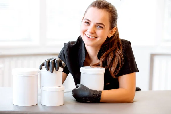 Portret Van Een Schoonheidsspecialiste Een Zwarte Jas Een Crème Pot — Stockfoto