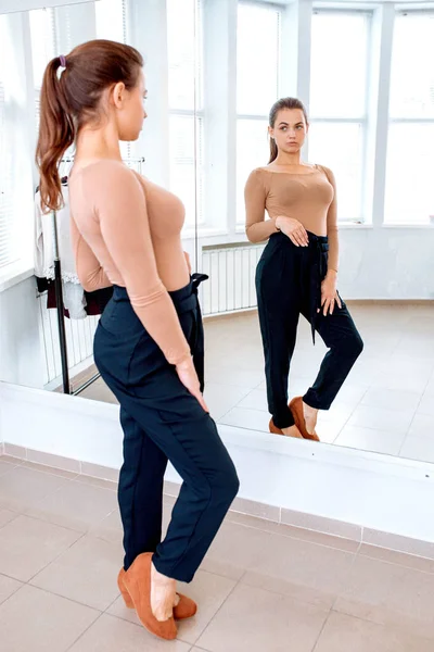 Krásná Sebevědomá Žena Při Pohledu Zrcadla Snaží Kalhoty — Stock fotografie