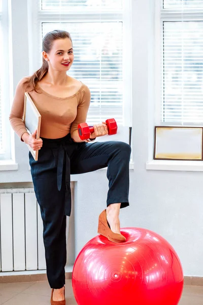 Business woman coach with dumbbell and diploma