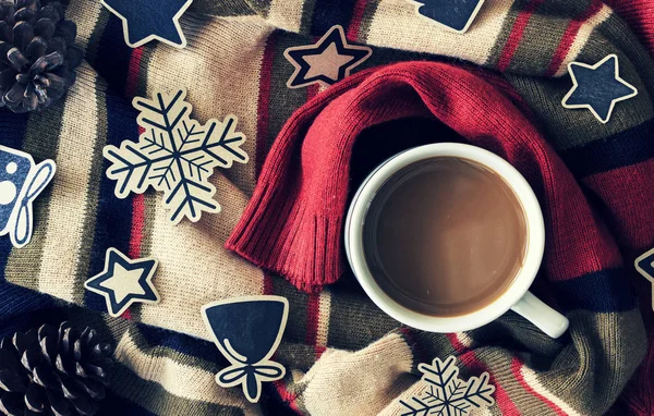 christmas concept. cup of coffee on red sweater background. over light and vintage tone