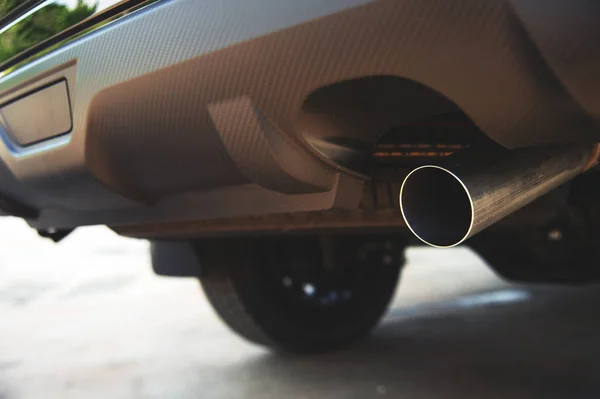 closeup car exhaust pipe with soft-focus and over light in the background